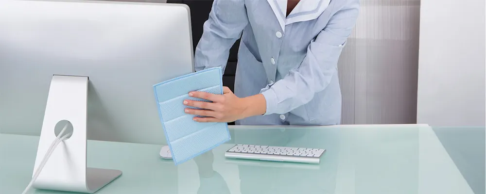 agent nettoyant un bureau avec un ordinateur : nettoyage de bureaux à Paris 3