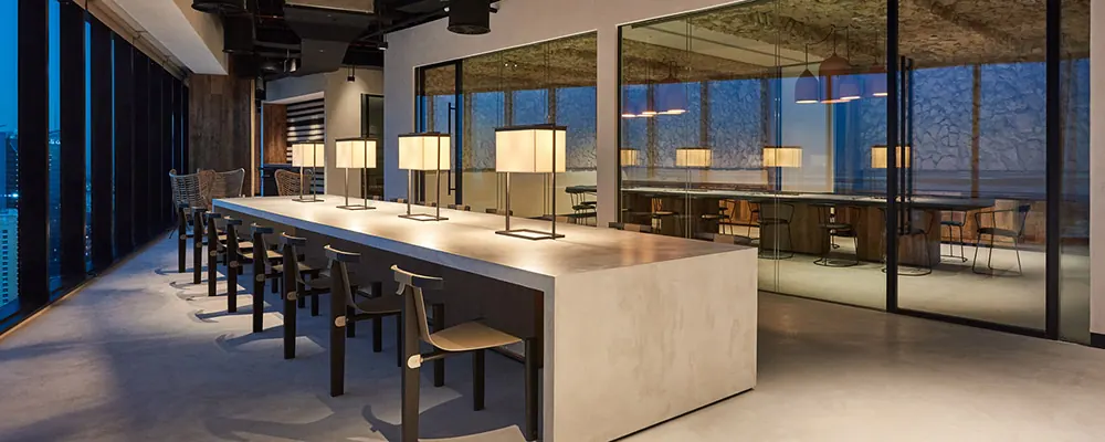 Grande table partagée dans un espace de coworking avec cloisons vitrées : nettoyage de coworking à Paris