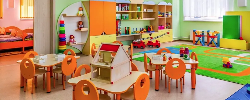 Salle d’activités d’une crèche avec tables et chaises d’enfants : fréquence de nettoyage d’une crèche