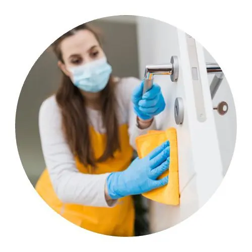 Société de nettoyage virucide par agent avec des gants bleus et chiffon jaune sur poignée de porte