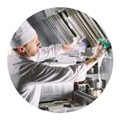 Entreprise Nettoyage de restaurants avec cuisinier dégraissant une hotte de cuisine professionnelle