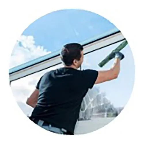 Service nettoyage vitres Paris et banlieue avec agent passant une raclette et mouilleur sur vitres
