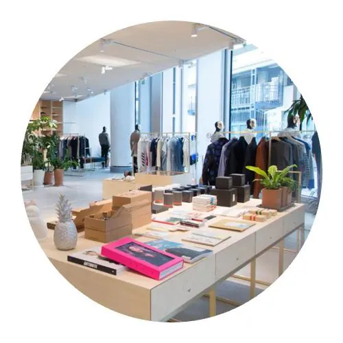 Société nettoyage expert de boutiques devant un étalage de vêtement rangés et sur des portants